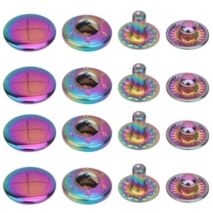 May include: A set of four iridescent rainbow-coloured metal snap fasteners arranged in rows. Each set includes a smooth domed cap, a ring-shaped socket with star detailing, a post with a scalloped base, and a small circular stud component.