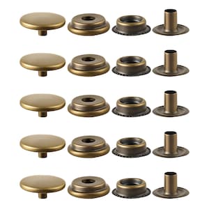 May include: A collection of antique brass-toned snap fasteners. The components include round cap pieces, socket pieces, eyelet pieces, and post pieces. The fasteners are arranged in rows, showing the different parts needed for assembly.
