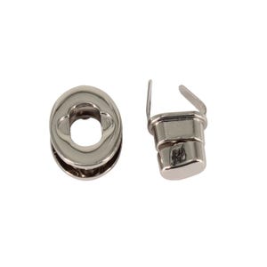 May include: A silver metal snap fastener set with a round, oval-shaped base and a rectangular top piece. The snap fastener is used for attaching fabric or leather together.