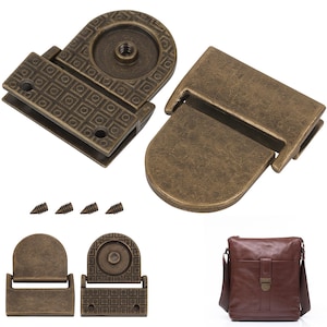 Könnte beinhalten: Ein Set aus antik-messingfarbenen Metallbeschlägen für Taschen, bestehend aus einem zweiteiligen rechteckigen Verschluss mit geometrischem Quadratmuster, einem glatten runden Riegel und vier kleinen Schrauben, neben einer braunen Ledertasche.