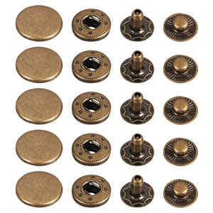 Könnte beinhalten: Ein Set aus fünf bronzefarbenen Metalldruckknöpfen, angeordnet in vier Spalten. Jedes Set besteht aus einer glatten runden Kappe, einem Ring mit Sternengravuren, einem zentralen Stiftteil und einem strukturierten Basisteil mit Rillen.