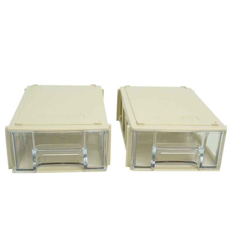 May include: Two beige plastic storage drawers with clear plastic fronts. The drawers are rectangular with a slightly textured surface and are designed to stack. The clear fronts allow for easy viewing of the contents.