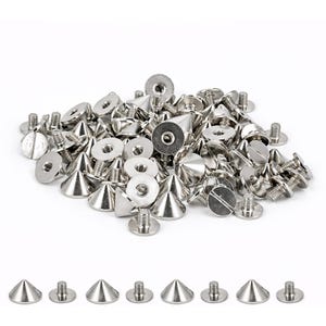 May include: A collection of silver-coloured metal cone-shaped studs with flat circular bases and threaded screw posts. The studs feature a pointed top and a smooth, reflective finish. Several individual studs are arranged in a row below the main pile.