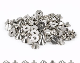 May include: A collection of silver-colored metal cone-shaped studs with flat circular bases and threaded screw posts. The studs feature a pointed top and a smooth, reflective finish. Several individual studs are arranged in a row below the main pile.