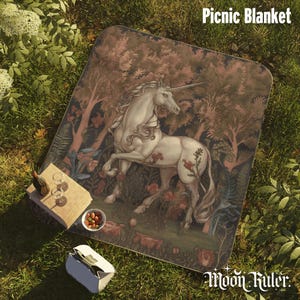 May include: A rectangular picnic blanket featuring a detailed illustration of a white unicorn standing in a forest with trees and flowers. The blanket has rounded corners and displays the text Picnic Blanket and Moon Ruler.