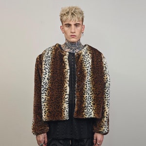 May include: A brown and white faux fur jacket with a leopard print pattern. The jacket has a button closure and long sleeves.