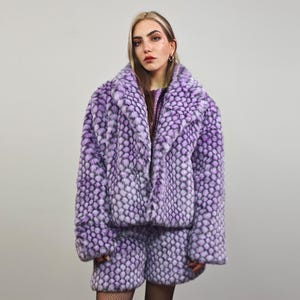 May include: A purple faux fur jacket and matching shorts with a geometric pattern. The jacket has a large collar and a zip closure.