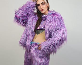 May include: A vibrant, fluffy purple faux fur jacket and matching pants set. The jacket has long sleeves and a shaggy texture. The outfit is paired with a sequined crop top. The ensemble is a bold fashion statement.