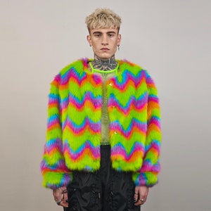 May include: A colourful faux fur jacket with a zig-zag pattern in shades of green, pink, orange, and blue. The jacket has a button closure and long sleeves.