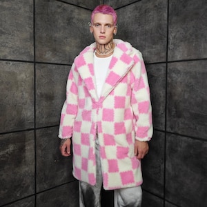 May include: A long, open-front coat in a pink and white checkerboard pattern. The coat has a plush, textured appearance and a wide collar. The garment is knee-length and appears to be made of a soft, warm material.