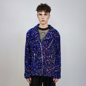 Può includere: Giacca blu con paillettes e chiusura con cerniera argentata. Design biker classico con colletto a revers e maniche lunghe. Le paillettes creano un effetto scintillante, riflettendo vari colori. Un capo d'abbigliamento audace.