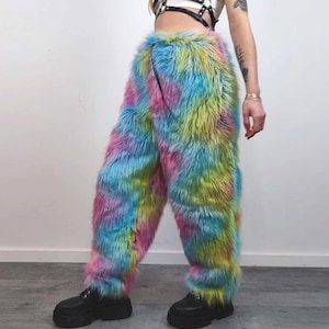 Könnte beinhalten: Hose aus mehrfarbigem Kunstfell in Rosa, Gelb, Blau und Grün. Die Hose wird mit schwarzen Plateau-Stiefeln getragen. Diese Statement-Hose ist eine auffällige Modeauswahl.