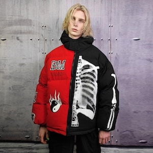 May include: A two-tone puffer jacket, half red and half black, with a hood. The red side features white graphics and the letters "BM". The black side displays a white skeleton design.