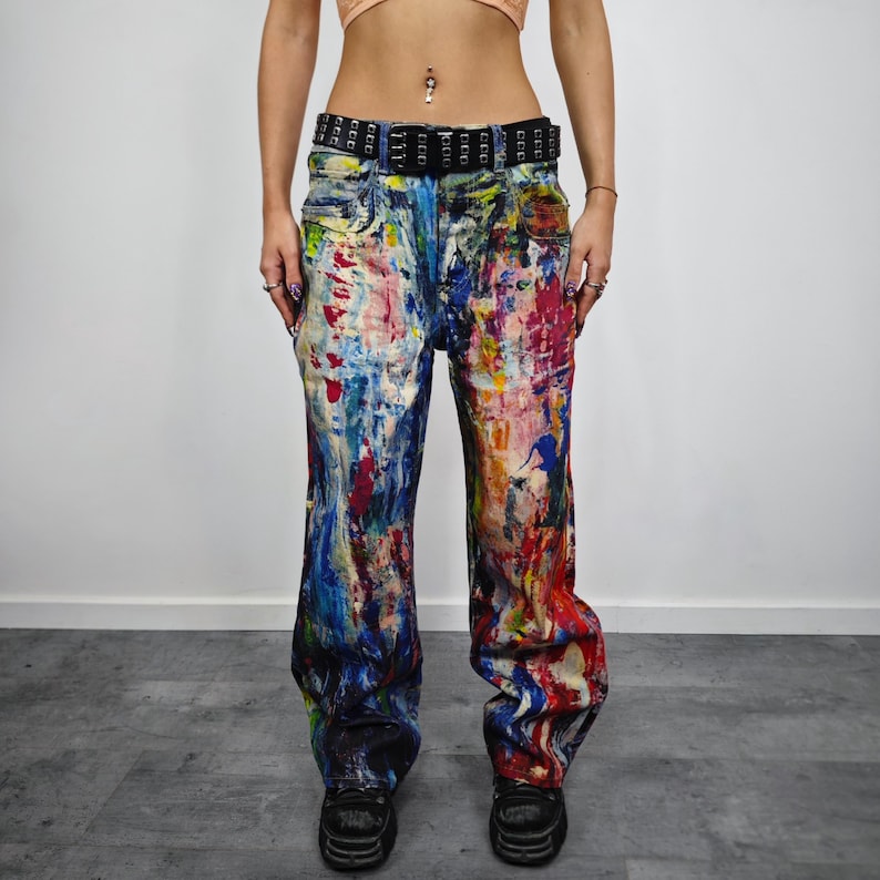 Express your bold style with these unisex paint splatter jeans, featuring vibrant colors and an edgy artistic vibe. Perfect for streetwear fans, skaters, festival goers, and creatives who love standout fashion. These jeans blend comfort with individuality, making them ideal for concerts, parties, raves, or everyday wear. A must-have for Y2K, grunge, and alternative fashion lovers seeking a unique wardrobe staple that turns heads and sets trends.
