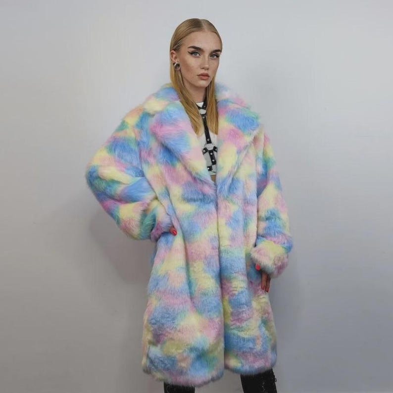 Step into a fantasy with this spectacular Pastel Faux Fur Long Unicorn Coat! The voluminous, fluffy fur features a magical, tie-dye rainbow of soft pinks, blues, and yellows. The dramatic long trench silhouette and oversized fit make it perfect for commanding attention. This unisex piece is your essential layer for Burner events, raver nights, and festival days. It’s the ultimate fluffy fleece jacket for a bold, maximalist statement.