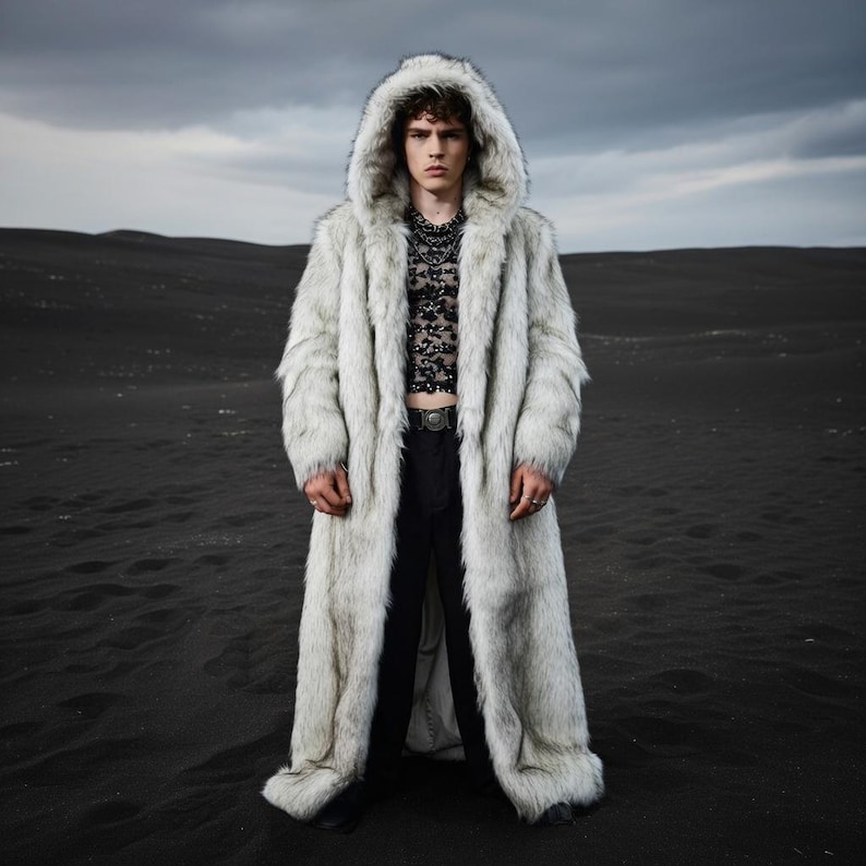 May include: A long, hooded faux fur coat in shades of white and gray. The coat is worn over a black top and pants. The model is standing in a dark, desolate landscape. The coat has a full length and a soft, textured appearance.
