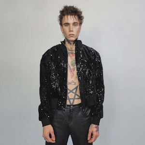 This embellished varsity jacket is the definition of dark glamour. The gloss glitter sequins create an unforgettable shiny effect. Styled as an oversized cropped blazer or a short bomber, this unisex embellished piece is ready for the club or a festive gathering. A durable, show-stopping coat for your boldest maximalist ensembles, providing the essential sparkle for any disco look.