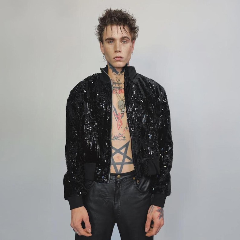 This embellished varsity jacket is the definition of dark glamour. The gloss glitter sequins create an unforgettable shiny effect. Styled as an oversized cropped blazer or a short bomber, this unisex embellished piece is ready for the club or a festive gathering. A durable, show-stopping coat for your boldest maximalist ensembles, providing the essential sparkle for any disco look.