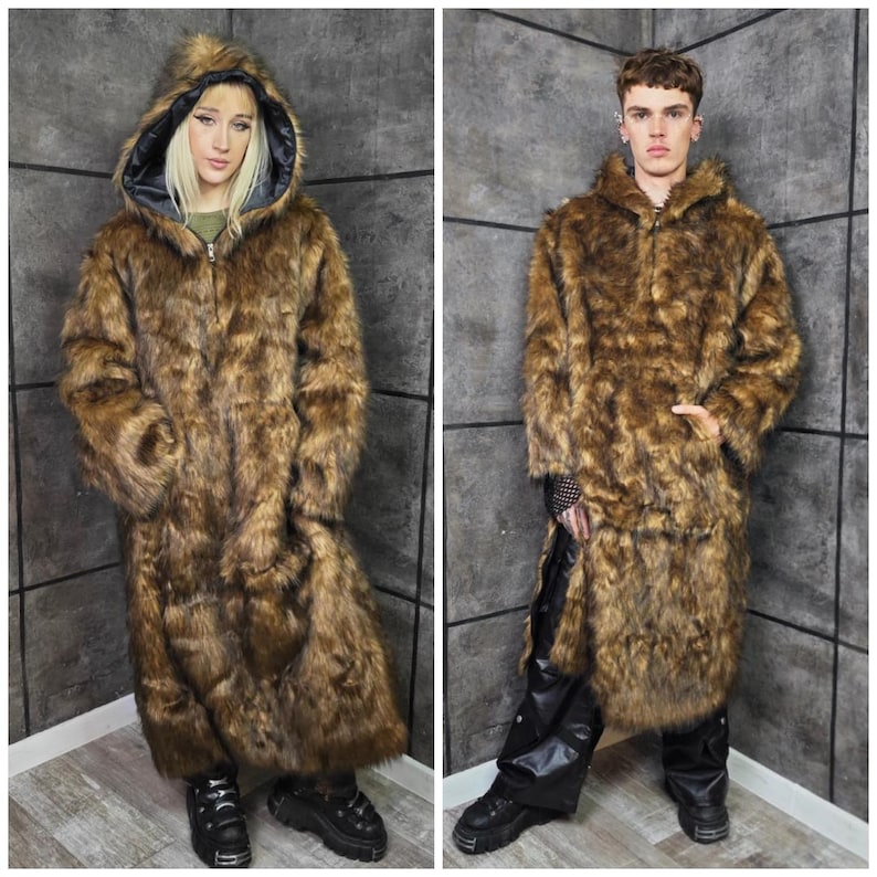 May include: Two full-length brown faux fur coats with hoods and zip closures. The coats have a shaggy texture and are worn by two people. The coats are floor-length and have a dark lining in the hood. The people are wearing black boots.