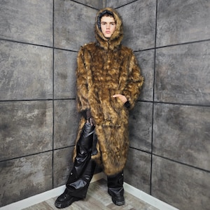 May include: A full-length brown faux fur coat with a hood. The coat has a zipper closure and a long, flowing design. The person is wearing black leather pants and black boots. The coat is a statement piece, perfect for a bold fashion statement.