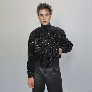 This embellished varsity jacket is the definition of dark glamour. The gloss glitter sequins create an unforgettable shiny effect. Styled as an oversized cropped blazer or a short bomber, this unisex embellished piece is ready for the club or a festive gathering. A durable, show-stopping coat for your boldest maximalist ensembles, providing the essential sparkle for any disco look.