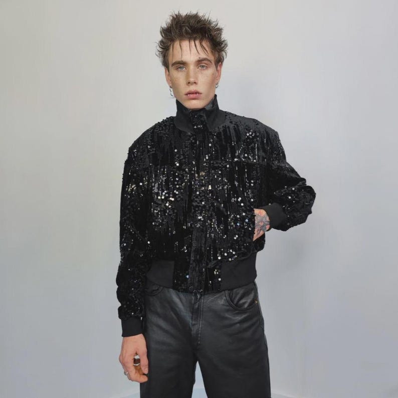 This embellished varsity jacket is the definition of dark glamour. The gloss glitter sequins create an unforgettable shiny effect. Styled as an oversized cropped blazer or a short bomber, this unisex embellished piece is ready for the club or a festive gathering. A durable, show-stopping coat for your boldest maximalist ensembles, providing the essential sparkle for any disco look.