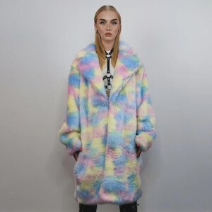 Step into a fantasy with this spectacular Pastel Faux Fur Long Unicorn Coat! The voluminous, fluffy fur features a magical, tie-dye rainbow of soft pinks, blues, and yellows. The dramatic long trench silhouette and oversized fit make it perfect for commanding attention. This unisex piece is your essential layer for Burner events, raver nights, and festival days. It’s the ultimate fluffy fleece jacket for a bold, maximalist statement.