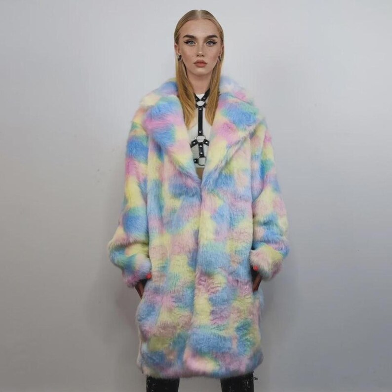 Step into a fantasy with this spectacular Pastel Faux Fur Long Unicorn Coat! The voluminous, fluffy fur features a magical, tie-dye rainbow of soft pinks, blues, and yellows. The dramatic long trench silhouette and oversized fit make it perfect for commanding attention. This unisex piece is your essential layer for Burner events, raver nights, and festival days. It’s the ultimate fluffy fleece jacket for a bold, maximalist statement.