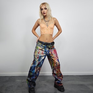 Express your bold style with these unisex paint splatter jeans, featuring vibrant colors and an edgy artistic vibe. Perfect for streetwear fans, skaters, festival goers, and creatives who love standout fashion. These jeans blend comfort with individuality, making them ideal for concerts, parties, raves, or everyday wear. A must-have for Y2K, grunge, and alternative fashion lovers seeking a unique wardrobe staple that turns heads and sets trends.