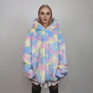 This coat is wearable bliss and pure dopamine dressing! The fluffy tie-dye fleece provides maximum winter warmth and a plush, shaggy texture. Its pastel rainbow blend is ideal for a "Doll Core" aesthetic or standing out on the Playa. This gender-fluid overcoat is your go-to for unique festival wear, blending the comfort of a puffer with the spirit of a raver bomber. The essential pink blue layer for your most whimsical going out looks.