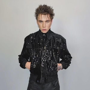 This embellished varsity jacket is the definition of dark glamour. The gloss glitter sequins create an unforgettable shiny effect. Styled as an oversized cropped blazer or a short bomber, this unisex embellished piece is ready for the club or a festive gathering. A durable, show-stopping coat for your boldest maximalist ensembles, providing the essential sparkle for any disco look.