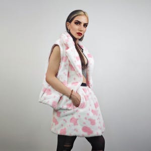 May include: A white and pink faux fur vest and skirt set. The vest has a collar and the skirt has a gathered waist.