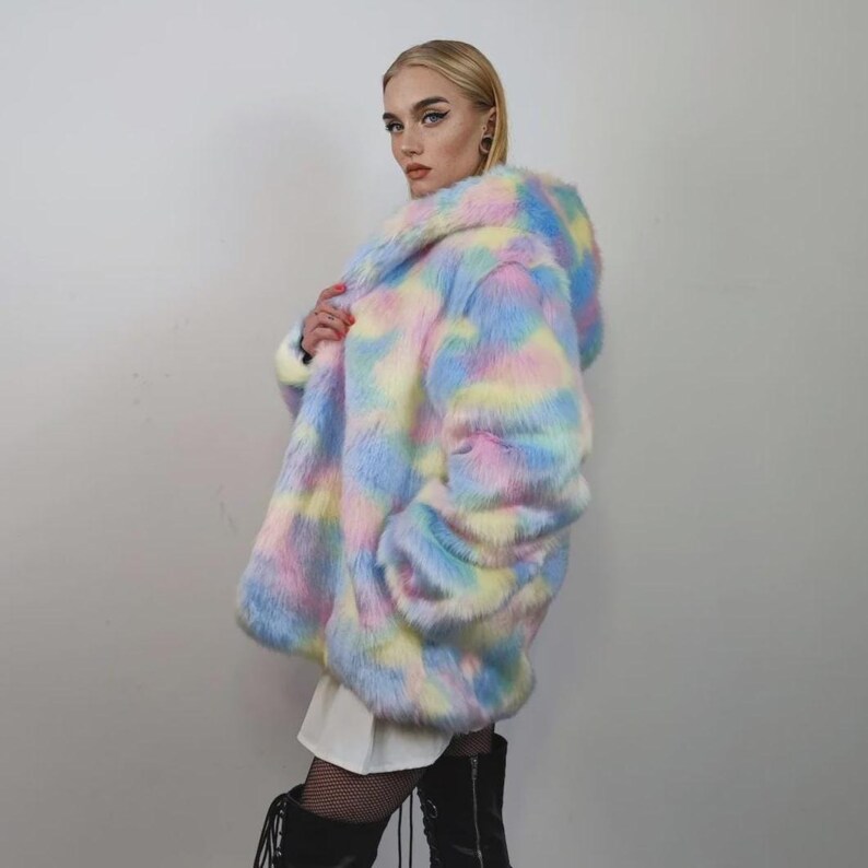 This coat is wearable bliss and pure dopamine dressing! The fluffy tie-dye fleece provides maximum winter warmth and a plush, shaggy texture. Its pastel rainbow blend is ideal for a "Doll Core" aesthetic or standing out on the Playa. This gender-fluid overcoat is your go-to for unique festival wear, blending the comfort of a puffer with the spirit of a raver bomber. The essential pink blue layer for your most whimsical going out looks.