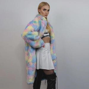 Step into a fantasy with this spectacular Pastel Faux Fur Long Unicorn Coat! The voluminous, fluffy fur features a magical, tie-dye rainbow of soft pinks, blues, and yellows. The dramatic long trench silhouette and oversized fit make it perfect for commanding attention. This unisex piece is your essential layer for Burner events, raver nights, and festival days. It’s the ultimate fluffy fleece jacket for a bold, maximalist statement.