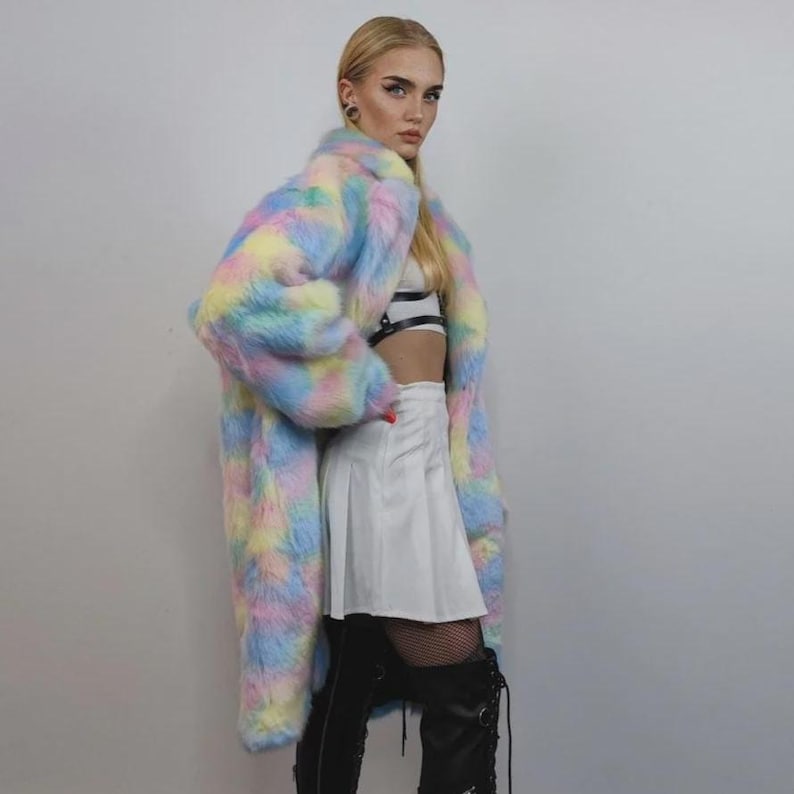Step into a fantasy with this spectacular Pastel Faux Fur Long Unicorn Coat! The voluminous, fluffy fur features a magical, tie-dye rainbow of soft pinks, blues, and yellows. The dramatic long trench silhouette and oversized fit make it perfect for commanding attention. This unisex piece is your essential layer for Burner events, raver nights, and festival days. It’s the ultimate fluffy fleece jacket for a bold, maximalist statement.