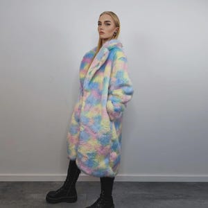 Step into a fantasy with this spectacular Pastel Faux Fur Long Unicorn Coat! The voluminous, fluffy fur features a magical, tie-dye rainbow of soft pinks, blues, and yellows. The dramatic long trench silhouette and oversized fit make it perfect for commanding attention. This unisex piece is your essential layer for Burner events, raver nights, and festival days. It’s the ultimate fluffy fleece jacket for a bold, maximalist statement.