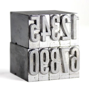 May include: A set of metal printing blocks with the numbers 1234 and 67890.