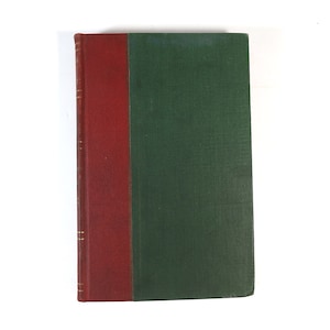 May include: A hardcover book with a red spine and a green cover. The spine has gold lettering and detailing. The book is set against a white background.