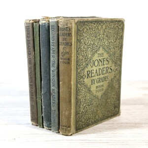 May include: A set of five vintage green and brown hardcover books titled "The Jones Readers by Grades" with the text "Book Four" on the front cover.