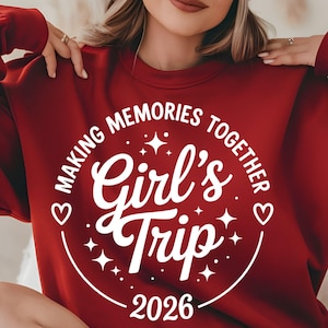 Peut inclure: Un sweat-shirt bordeaux avec l'inscription "MAKING MEMORIES TOGETHER Girl's Trip 2026" dans un cercle blanc. Le motif comprend des étoiles et des cœurs. Le sweat-shirt est de couleur bordeaux unie.