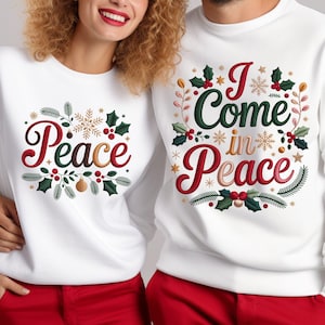 Peut inclure: Sweat-shirts blancs avec des pantalons rouges. L'un des sweat-shirts porte le mot "Peace" en rouge et vert avec des éléments décoratifs. L'autre sweat-shirt dit "I Come in Peace" en rouge et vert avec des éléments décoratifs.
