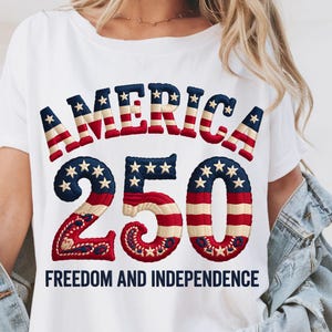 Peut inclure: T-shirt blanc avec l'inscription "AMERICA 250 FREEDOM AND INDEPENDENCE" dans un design patriotique. Le texte présente des couleurs rouge, blanc et bleu avec des motifs d'étoiles et de rayures, célébrant le 250e anniversaire.