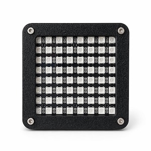 Peut inclure: Un panneau LED carré noir avec une grille de petites lumières blanches et brillantes. Le panneau est encadré par un bord noir texturé, fixé avec quatre vis argentées. Les lumières sont espacées uniformément, créant une lueur vive et uniforme. Dimensions en centimètres.