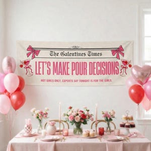 May include: A banner with the text "The Galentines Times" and "LET'S MAKE POUR DECISIONS" in pink. The banner is decorated with pink bows and cocktail glasses. The table is set with pink linens, flowers, candles, and cupcakes, with balloons in the background.