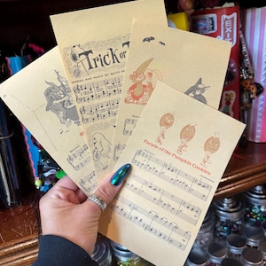 May include: A collection of four tan paper sheets featuring vintage-style Halloween illustrations and musical notation. The sheets display titles including Trick or Treat and Parade of the Pumpkin Cookies, accompanied by drawings of ghosts, witches, and pumpkin characters.