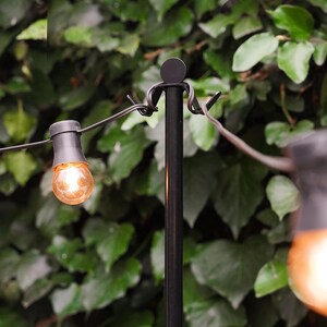 A close-up view of our metal poles designed for outdoor string lights. They feature a charming little figure at the top and a sleek, durable finish, perfect for creating a cozy and stylish outdoor ambiance.