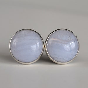 May include: A pair of silver earrings with blue agate stones. The stones have a swirling pattern.