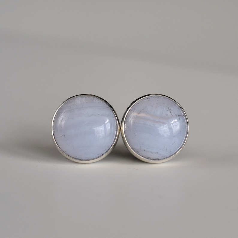 May include: A pair of silver earrings with blue agate stones. The stones have a swirling pattern.