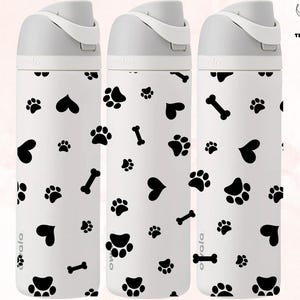 May include: Three white water bottles with black paw prints, hearts, and bone designs. The bottles have a gray lid and a white label with the word "ovala" on it.