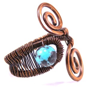 May include: A copper wire wrapped bracelet with a turquoise stone and two copper wire spirals.